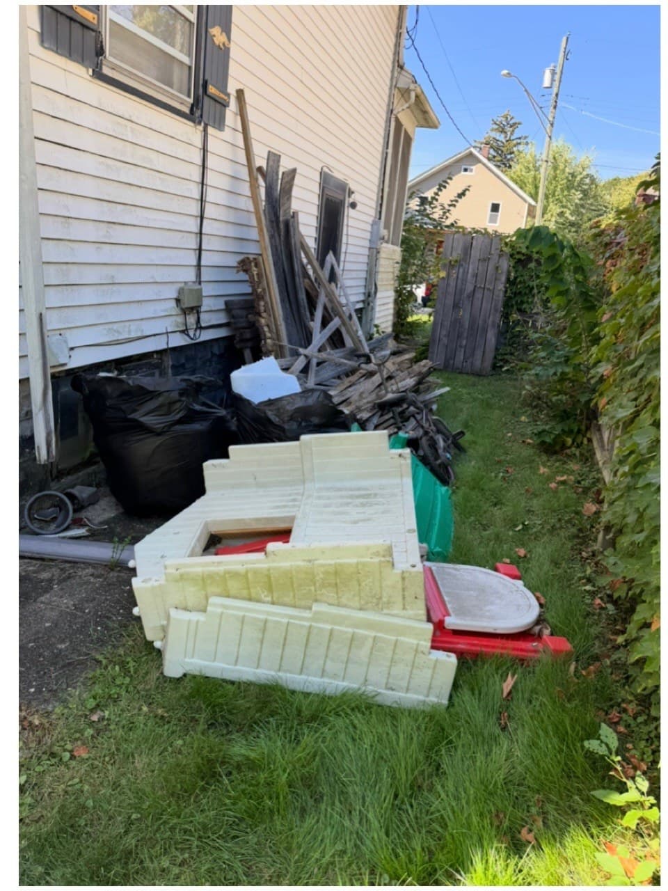 Junk removal in Rockford IL: side yard debris removal before